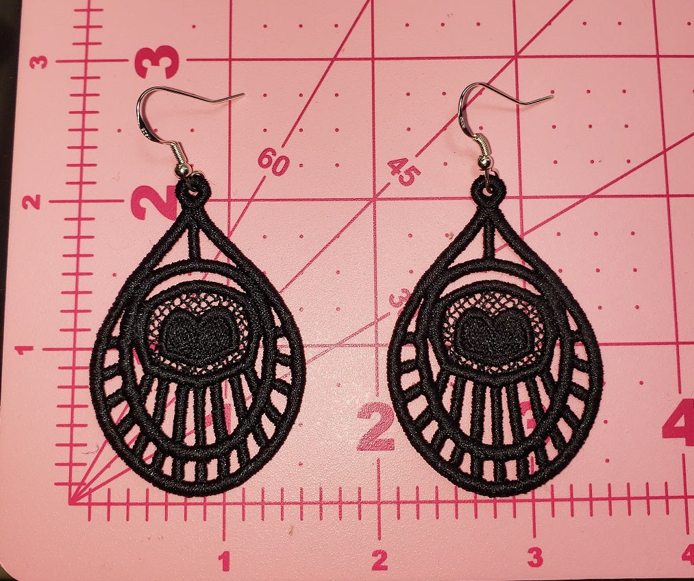 Size Teardrop Boho Heart Embroidered earrings on a pink cutting mat